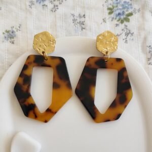 Boucles d'oreilles géométriques effet écaille marron et noir avec attache dorée martelée, style chic et moderne pour femme.