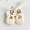 boucles d'oreilles écru forme organique avec attache dorée, bijoux minimalistes chic pour femme.
