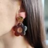 Boucle d'oreille pendante avec pendentif en forme de fleur marron en résine et clou d'oreille en acier inoxydable martelé doré.