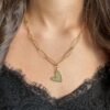 Collier doré à deux chaînes et pendentif cœur porté autour du coup