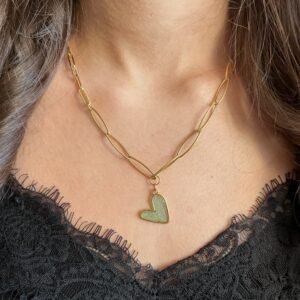 Collier doré à deux chaînes et pendentif cœur porté autour du coup