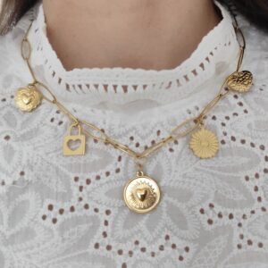 Collier avec breloques en acier inoxydable, porté autour du cou sur un tissu en dentelles blanc.